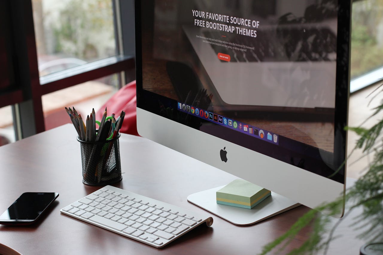 A clean, organized desk setup featuring a computer display, keyboard, and office supplies.